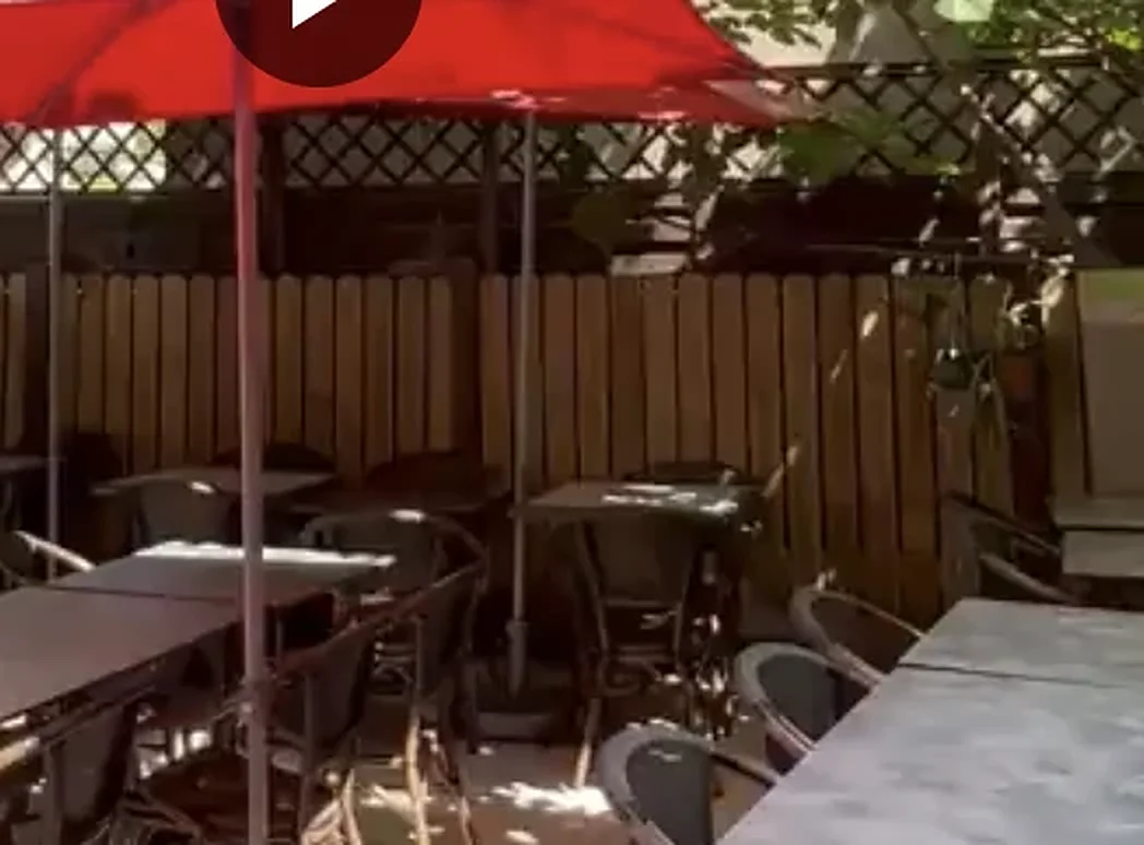 La terrasse ombragée du Massala, parasols rouges sous les arbres