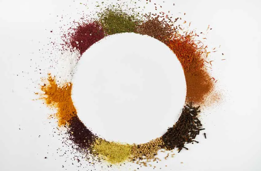 Cercle d'épices en poudre autour d'une assiette blanche